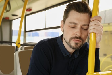 Photo of Tired man sleeping while sitting in public transport. Space for text