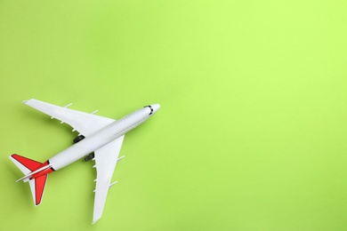 Photo of Toy airplane on green background, top view. Space for text