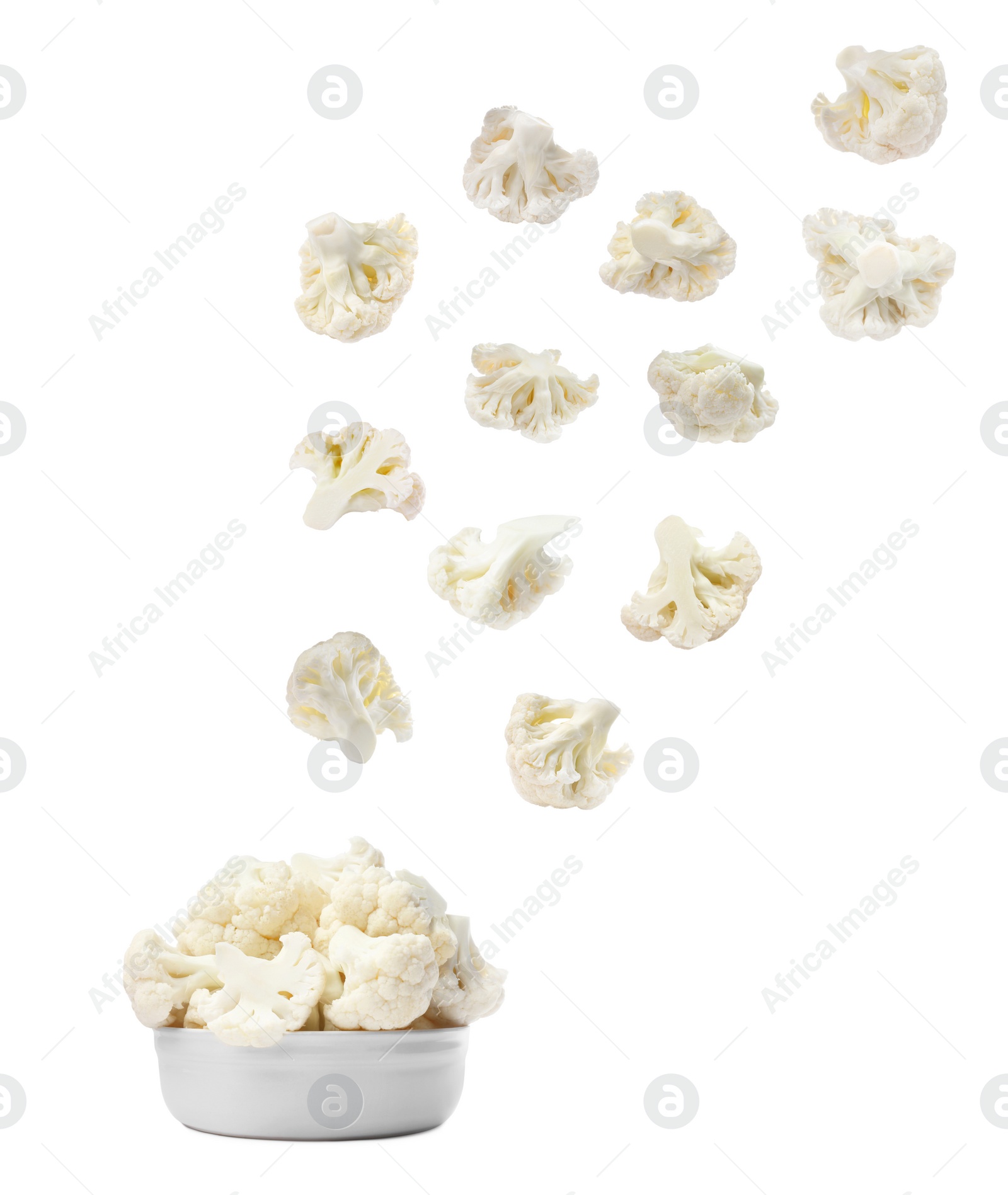 Image of Many fresh cauliflower florets falling into bowl on white background