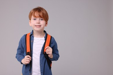 Photo of Happy schoolboy on grey background, space for text