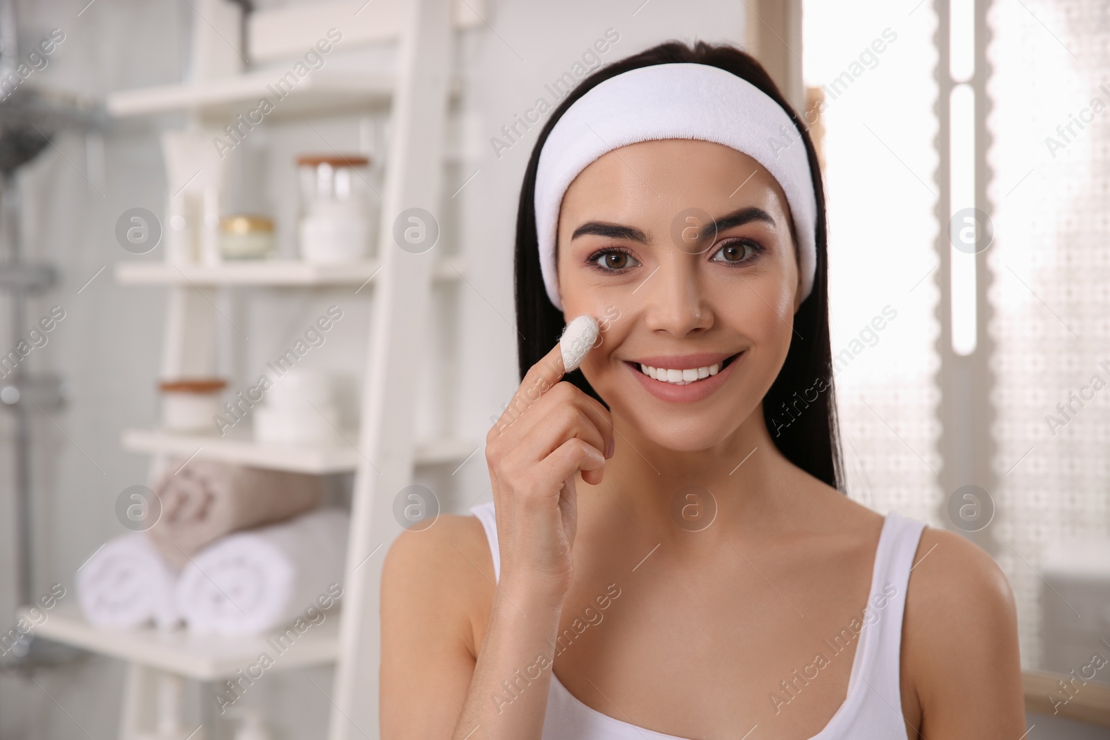 Photo of Woman using silkworm cocoon in skin care routine at home