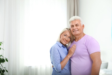 Photo of Portrait of happy senior couple at home. Space for text