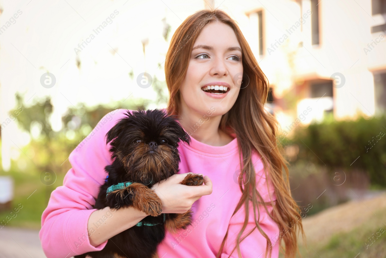 Photo of Young woman with adorable Brussels Griffon dog outdoors