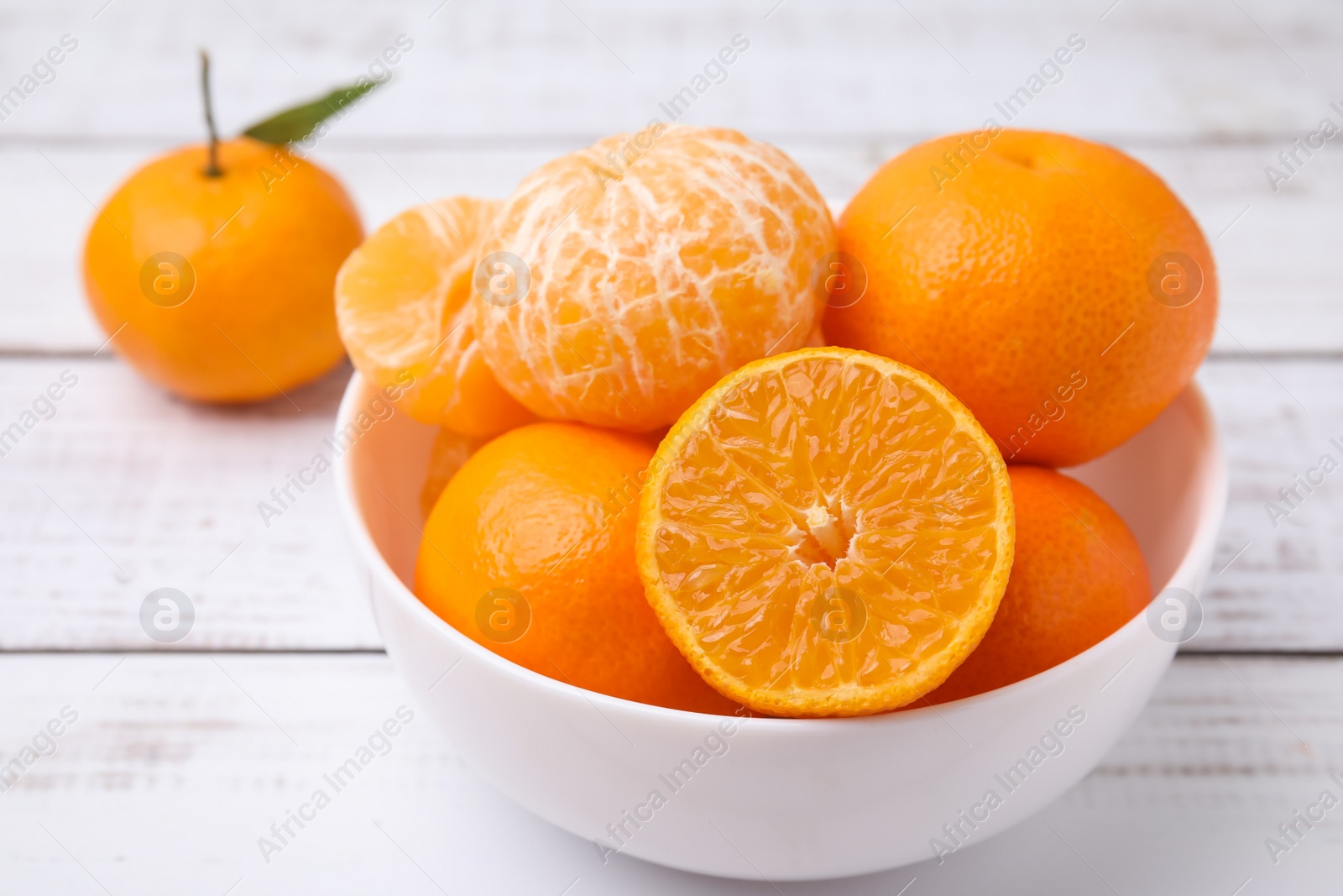 Photo of Fresh juicy tangerines on white wooden table, closeup