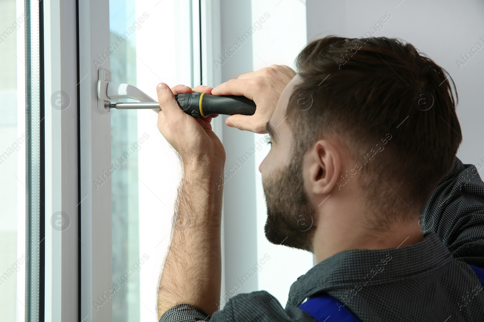 Photo of Professional construction worker installing window in apartment