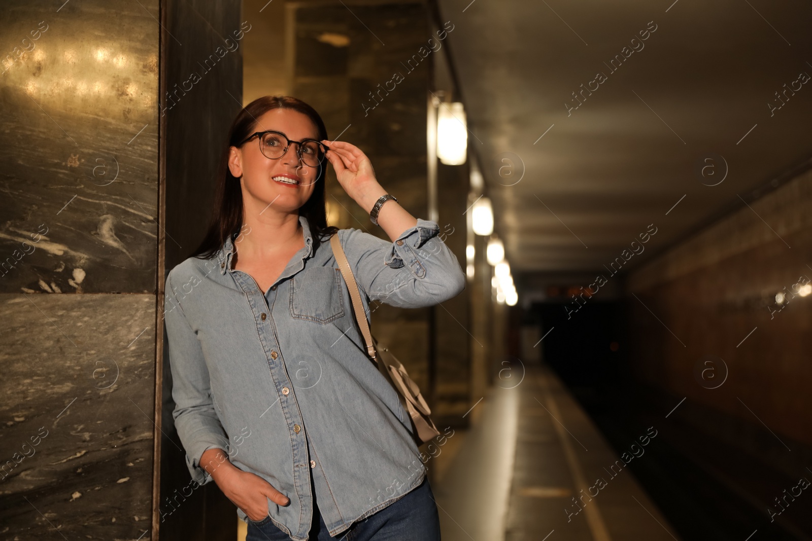 Photo of Beautiful woman with backpack on subway station. Public transport