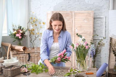 Female decorator creating beautiful bouquet at table