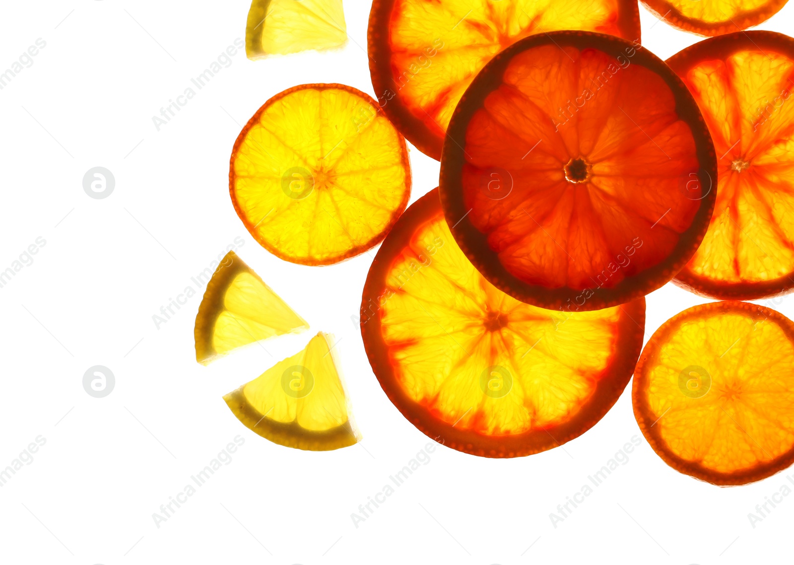 Photo of Illuminated slices of citrus fruits on white background, top view