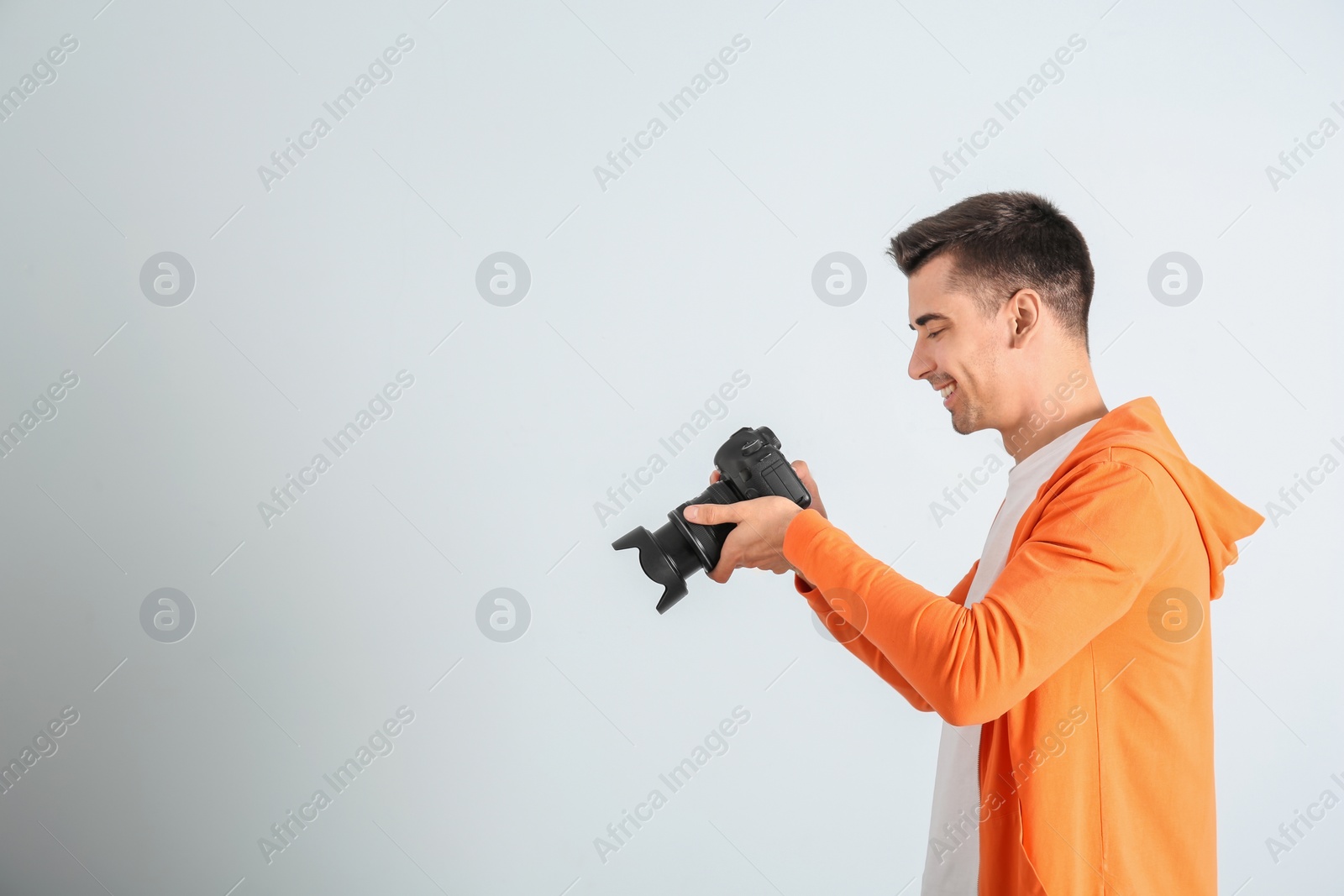 Photo of Male photographer with camera on light background