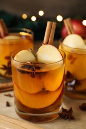 Hot mulled cider, cinnamon and anise on wooden tray, closeup