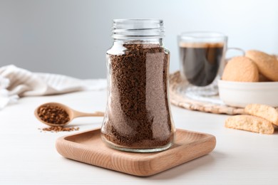 Photo of Jar of instant coffee on white wooden table