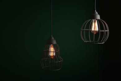 Hanging lamp bulbs in chandeliers against green background