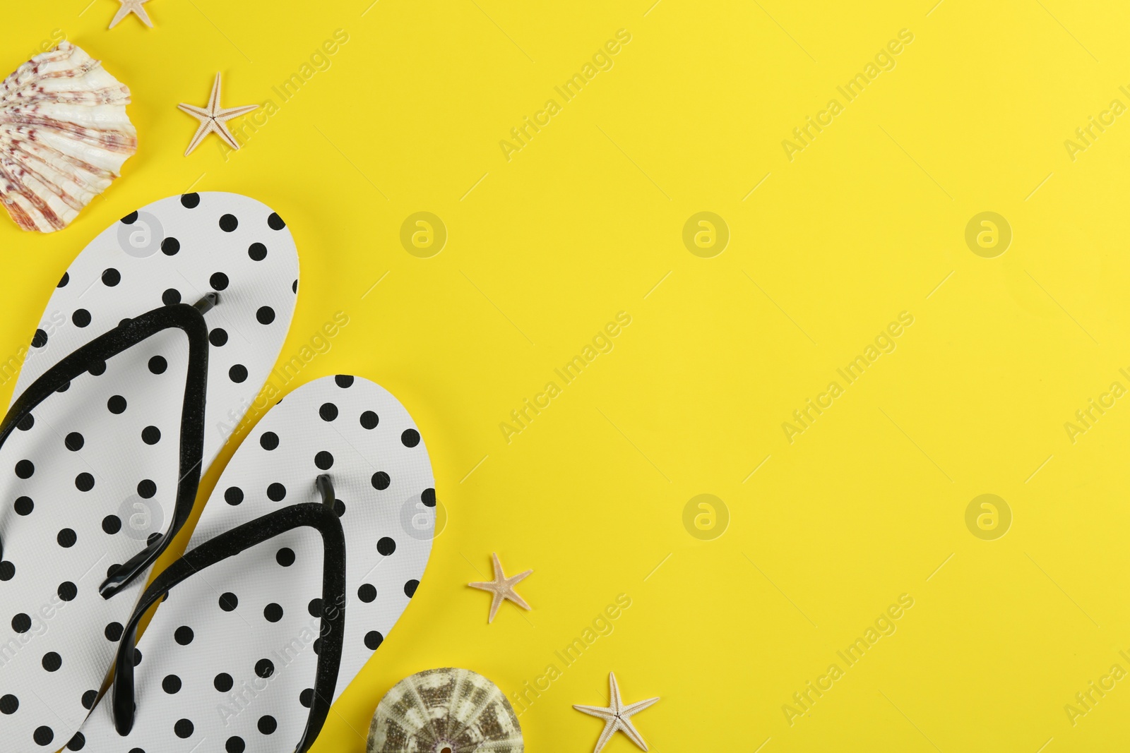 Photo of Flat lay composition with flip flops on yellow background. Space for text