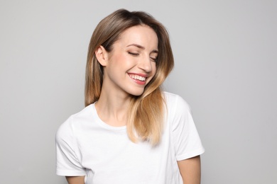 Portrait of young woman with beautiful face on grey background