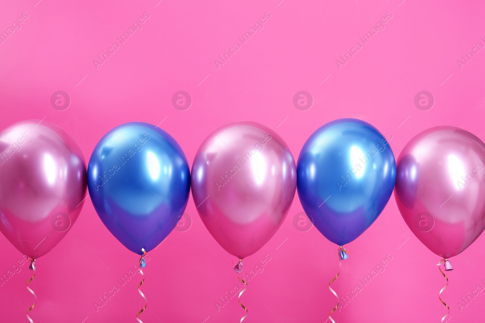 Photo of Bright balloons with ribbons on color background. Space for text