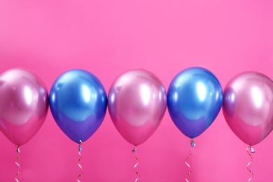 Photo of Bright balloons with ribbons on color background. Space for text