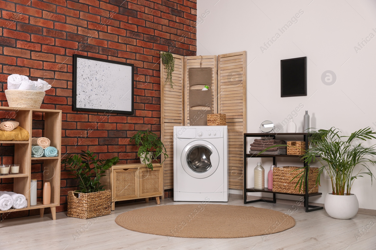 Photo of Stylish laundry room with washing machine. Interior design