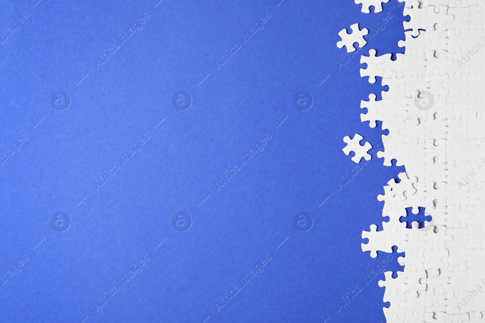 Photo of Blank white puzzle pieces on blue background, flat lay. Space for text