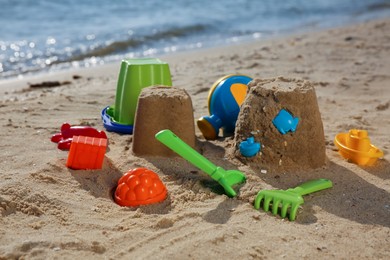 Set of plastic beach toys on sand near sea. Outdoor play