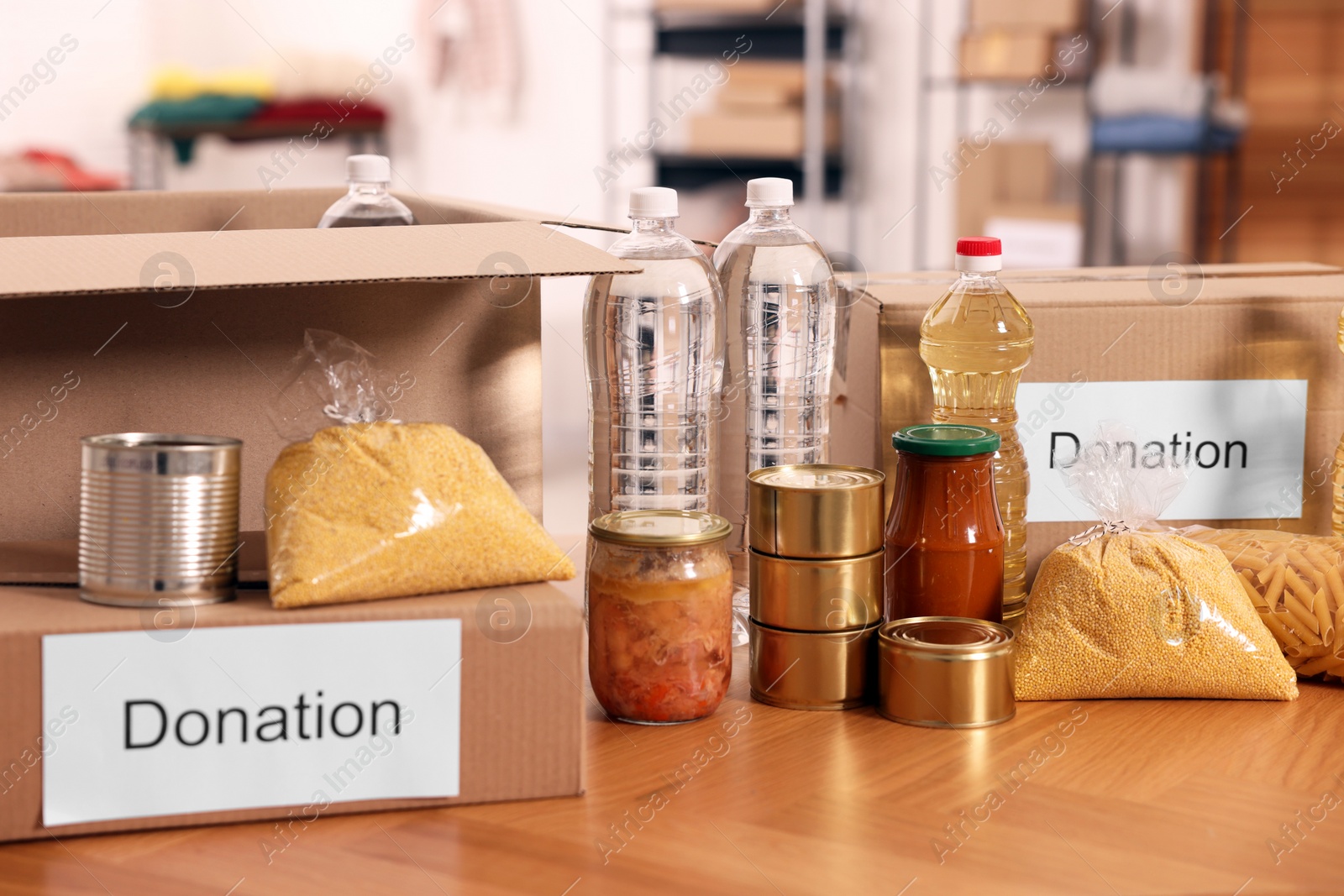 Photo of Volunteering. Different food products and cardboard boxes on table in warehouse