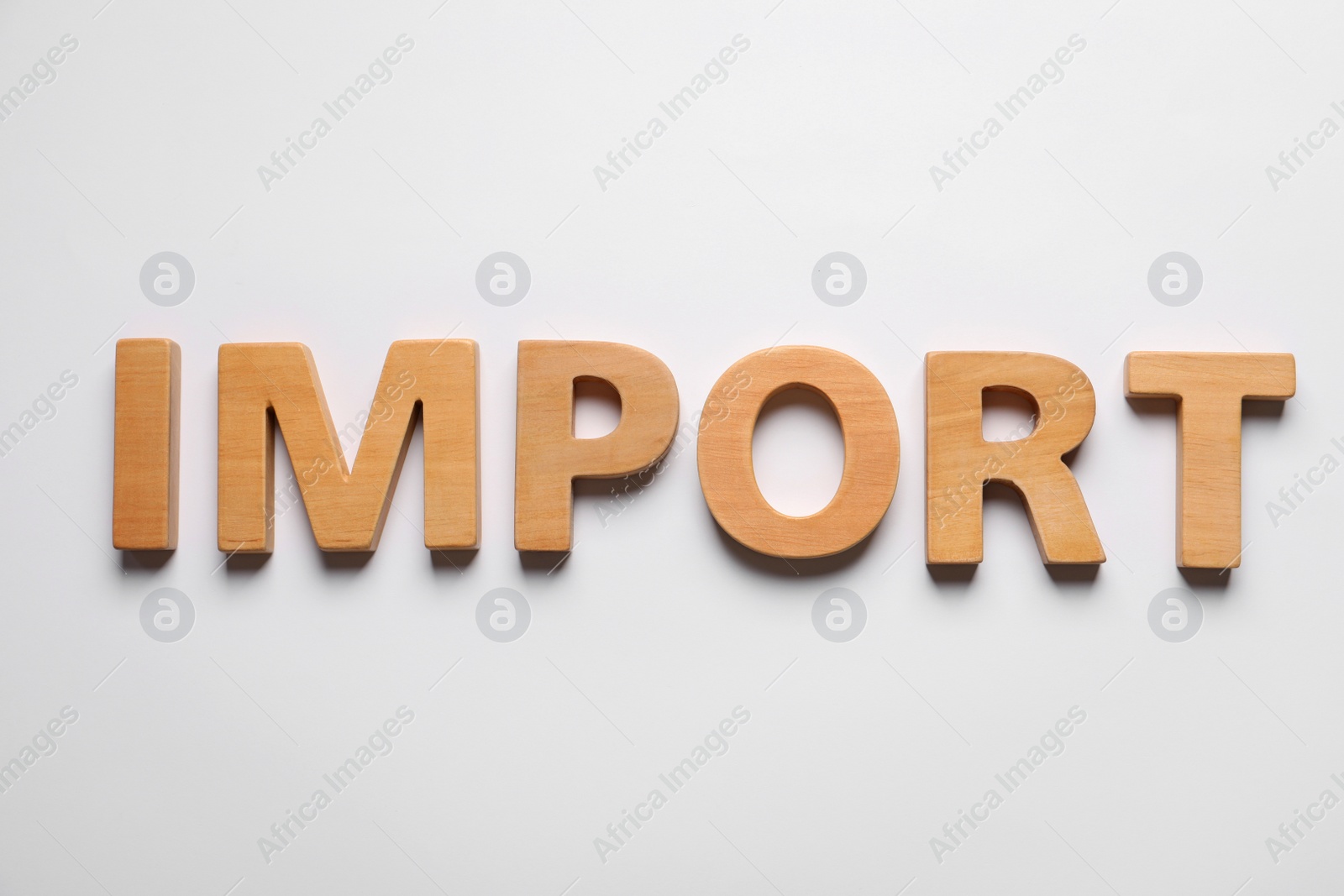 Photo of Word Import made of wooden letters on white background, flat lay