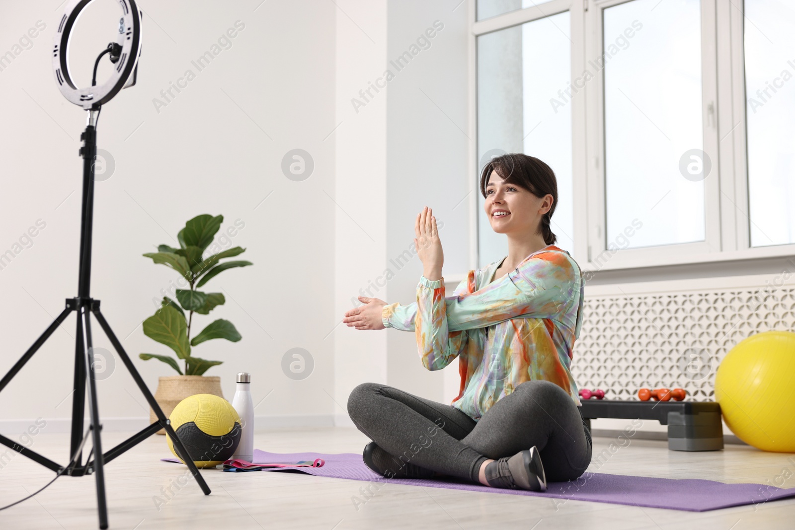 Photo of Happy sports blogger streaming online fitness lesson at home