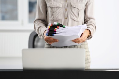 Businesswoman with documents in office, closeup view