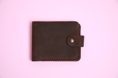 Photo of Stylish brown leather wallet on pink background, top view