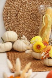 Photo of Composition with small pumpkins and beautiful flowers on table