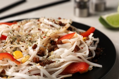 Photo of Plate with rice noodles, meat and vegetables, closeup