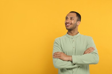 Photo of Portrait of handsome young man on orange background, space for text