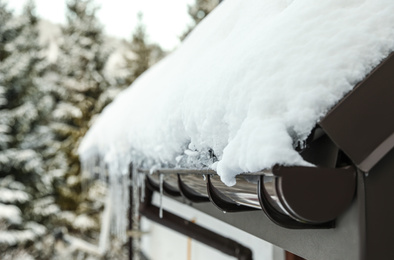 Photo of House roof covered with snow outdoors, closeup. Winter vacation