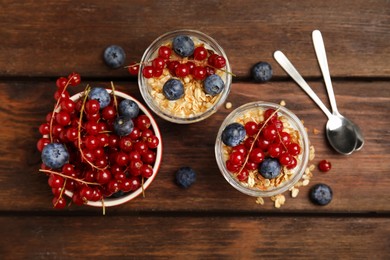 Delicious yogurt parfait with fresh berries on wooden table, flat lay