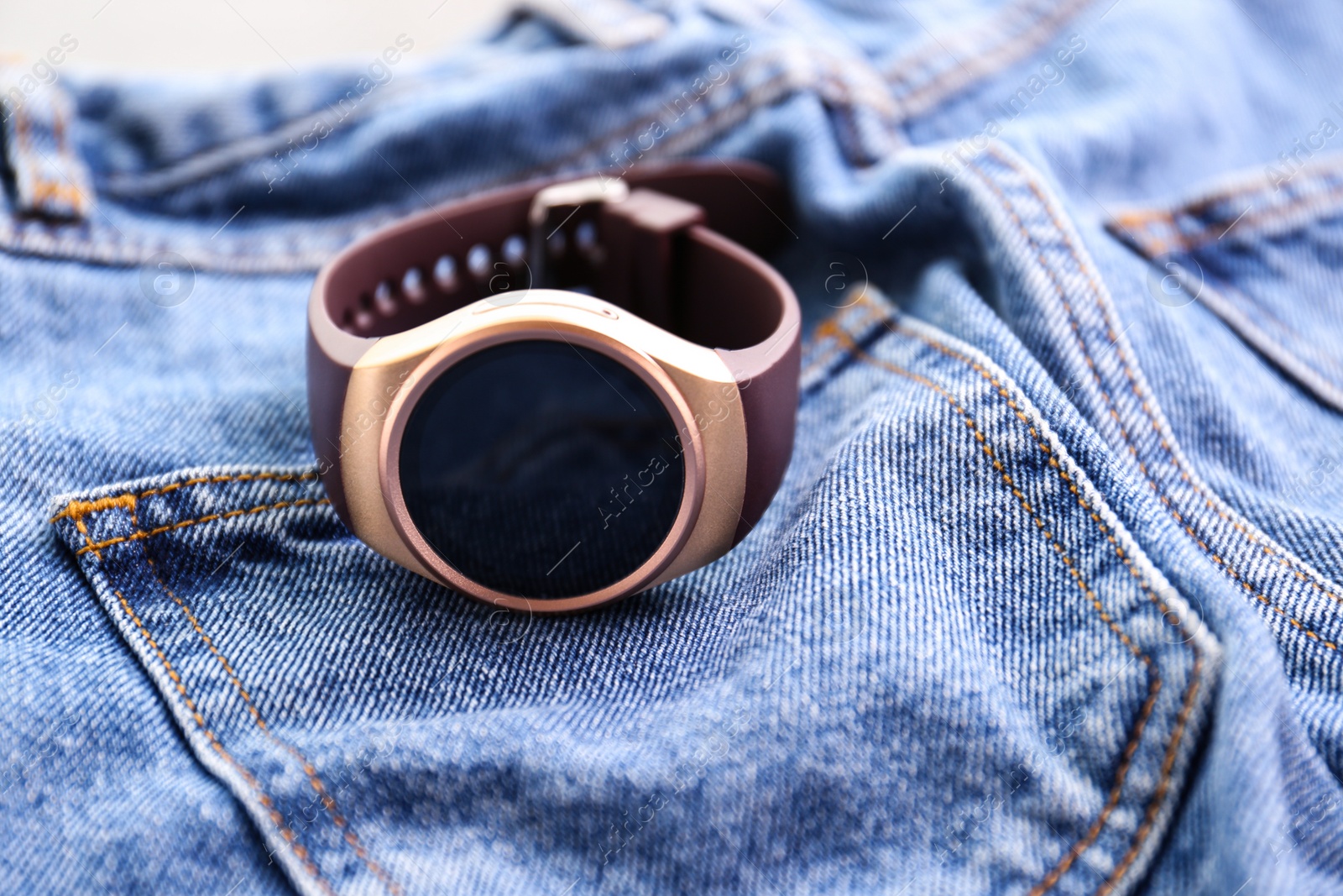 Modern stylish smart watch on jeans, closeup Photo of Modern stylish smart watch on jeans, closeup