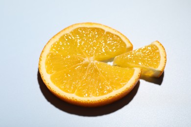 Slices of juicy orange on light blue background, closeup