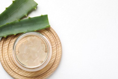 Photo of Aloe vera gel and slices of plant on white background, flat lay. Space for text