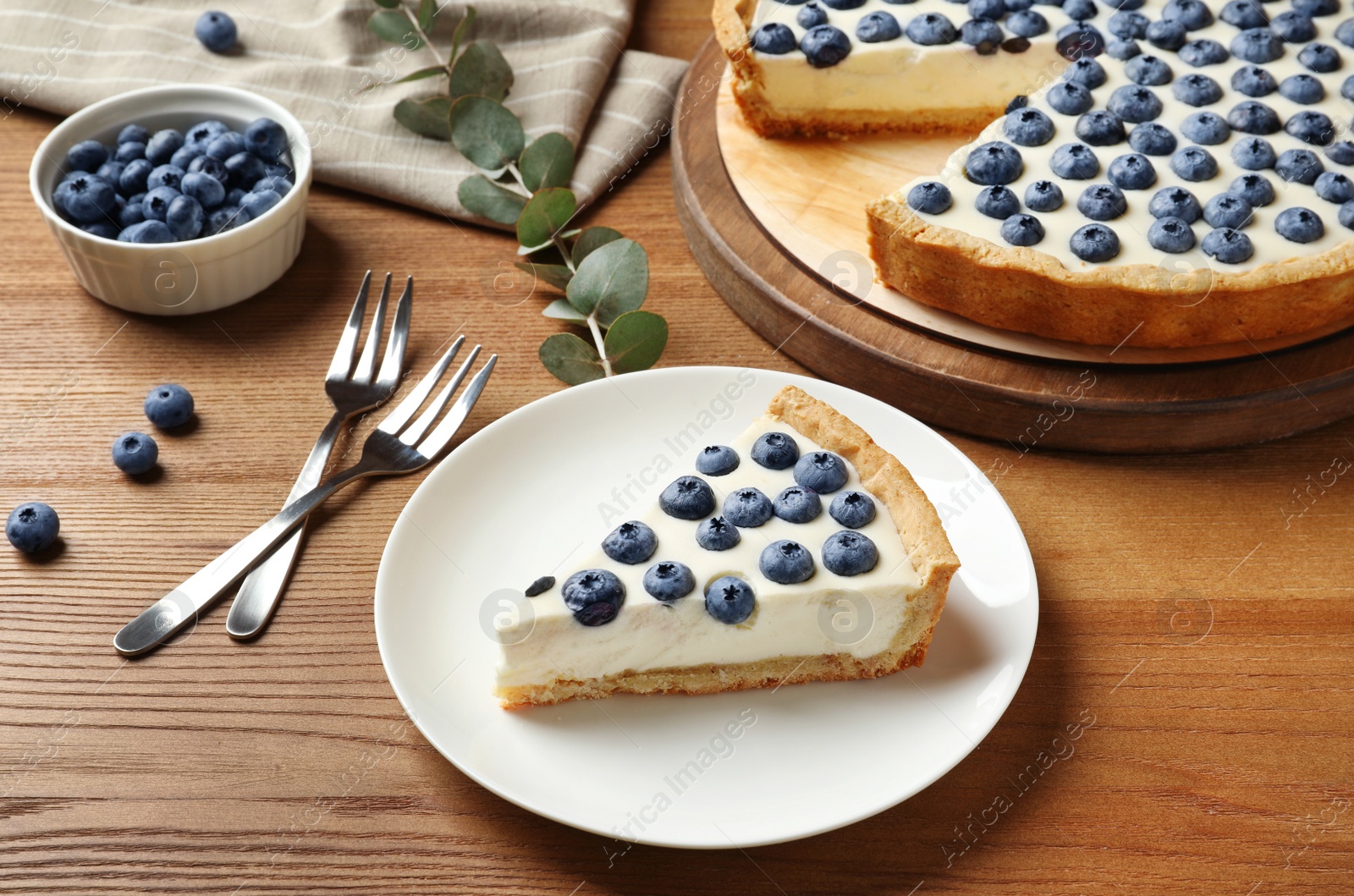 Photo of Plate with piece of tasty blueberry cake on wooden table