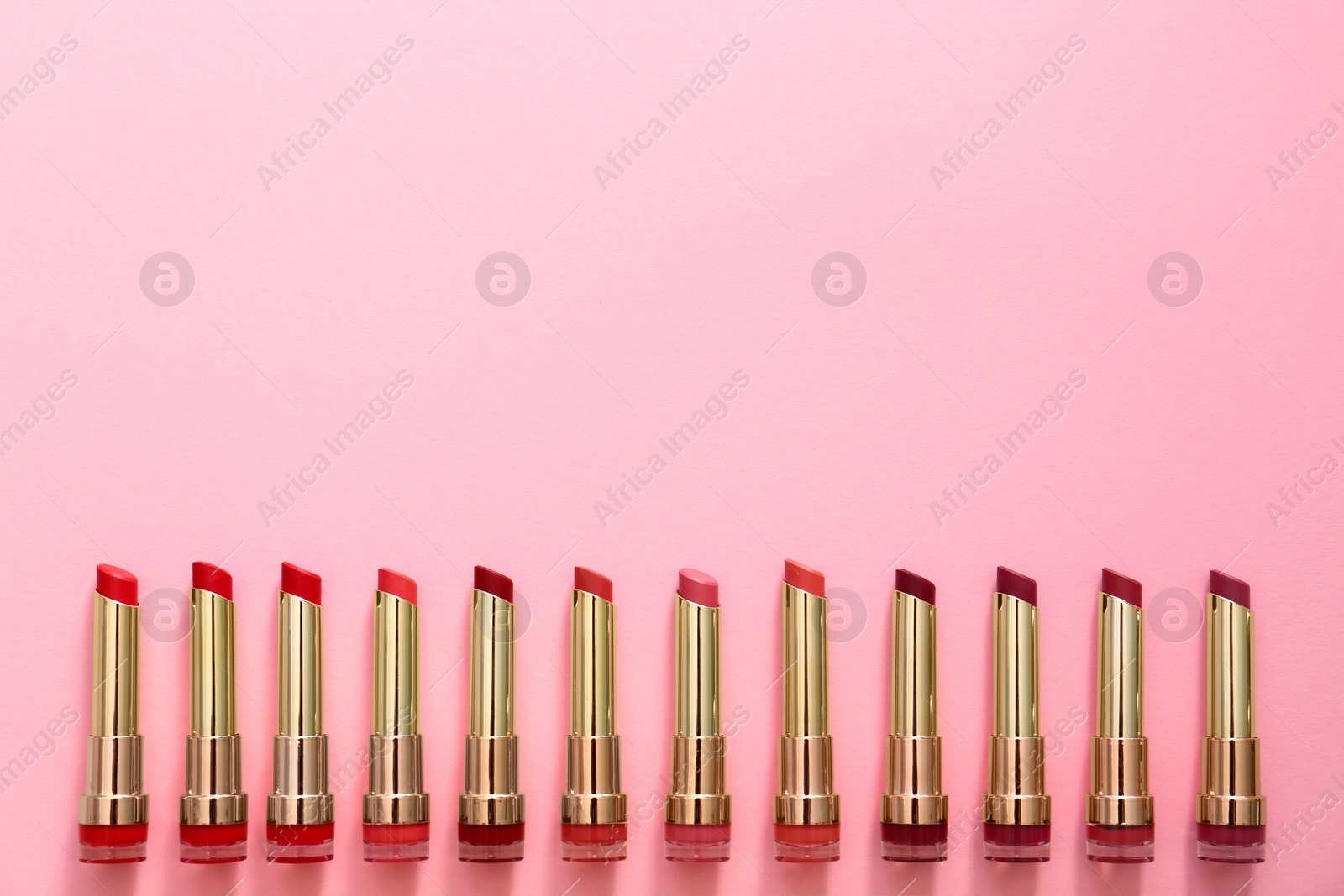 Photo of Flat lay composition with different lipsticks on color background, space for text
