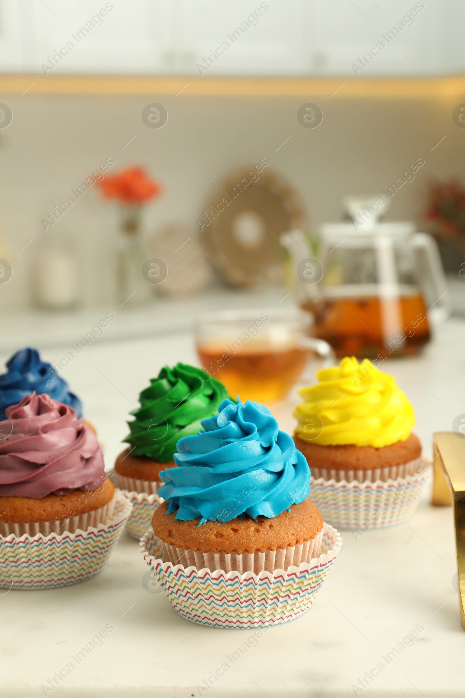 Photo of Delicious cupcakes with colorful cream on white board