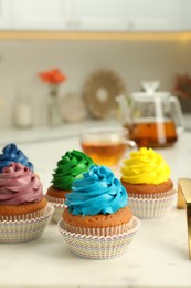 Photo of Delicious cupcakes with colorful cream on white board