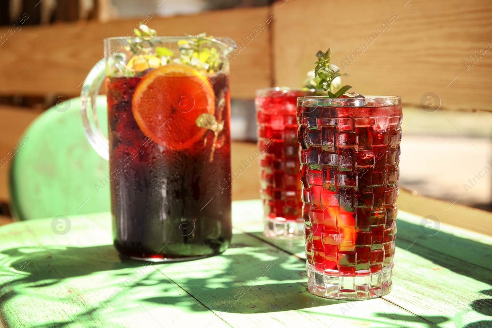 Photo of Glasses and jug with delicious cocktail on table in cafe