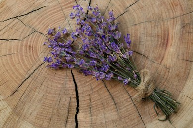 Photo of Bouquet of beautiful lavender flowers on wooden stump, top view