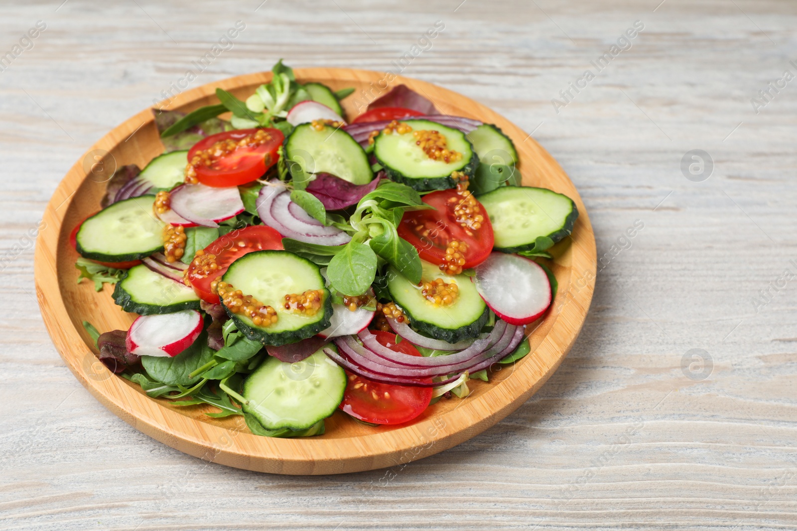 Photo of Tasty salad with different vegetables on wooden table