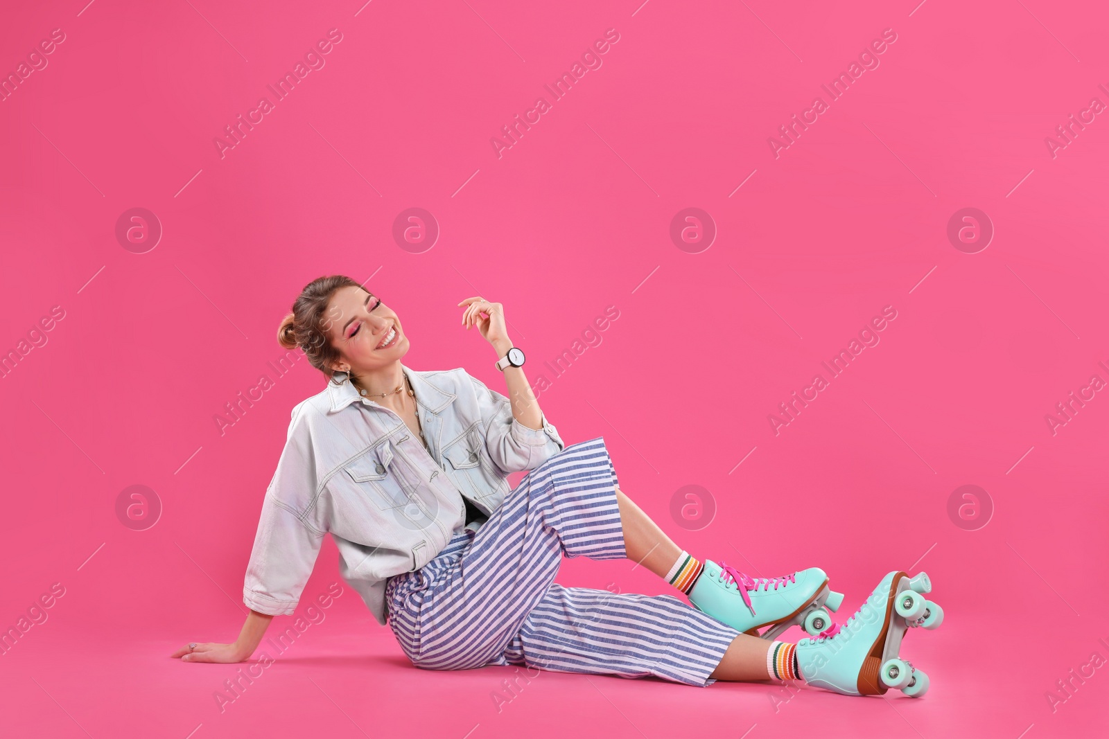 Photo of Young woman with retro roller skates on color background