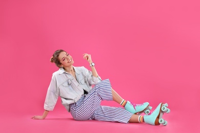 Photo of Young woman with retro roller skates on color background