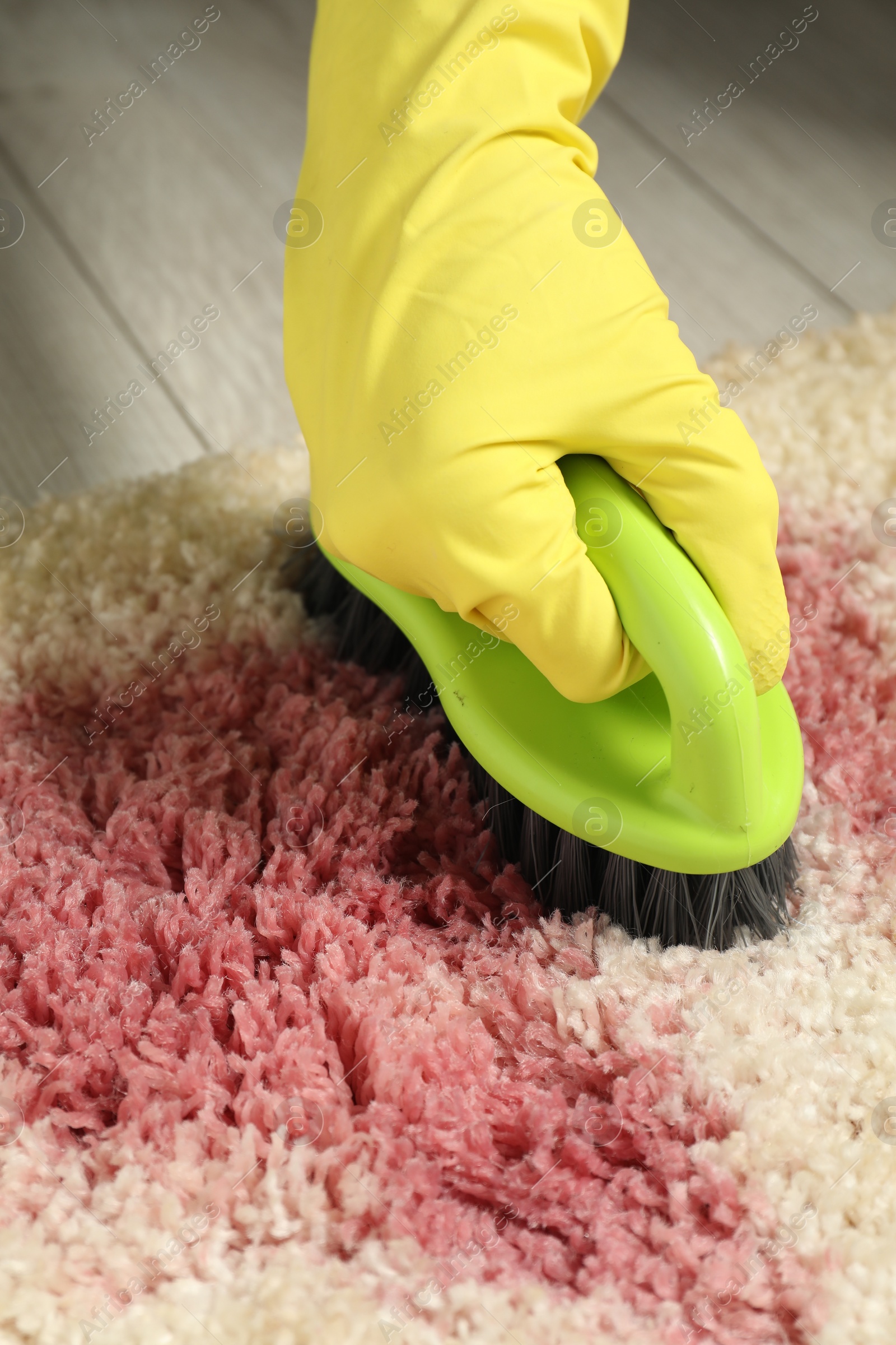 Photo of Woman removing stain from beige carpet, closeup