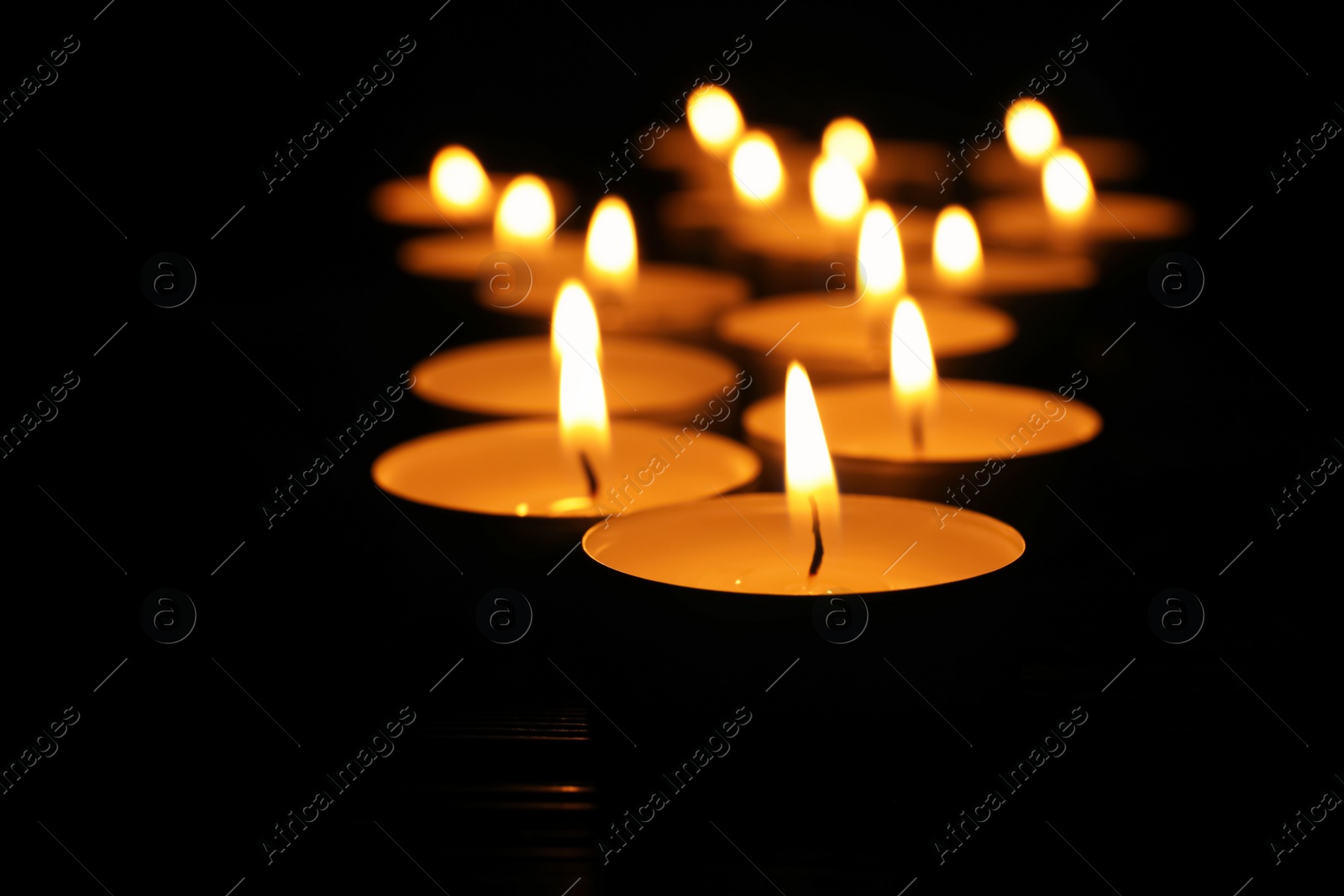 Photo of Burning candles on black background, closeup. Memory day