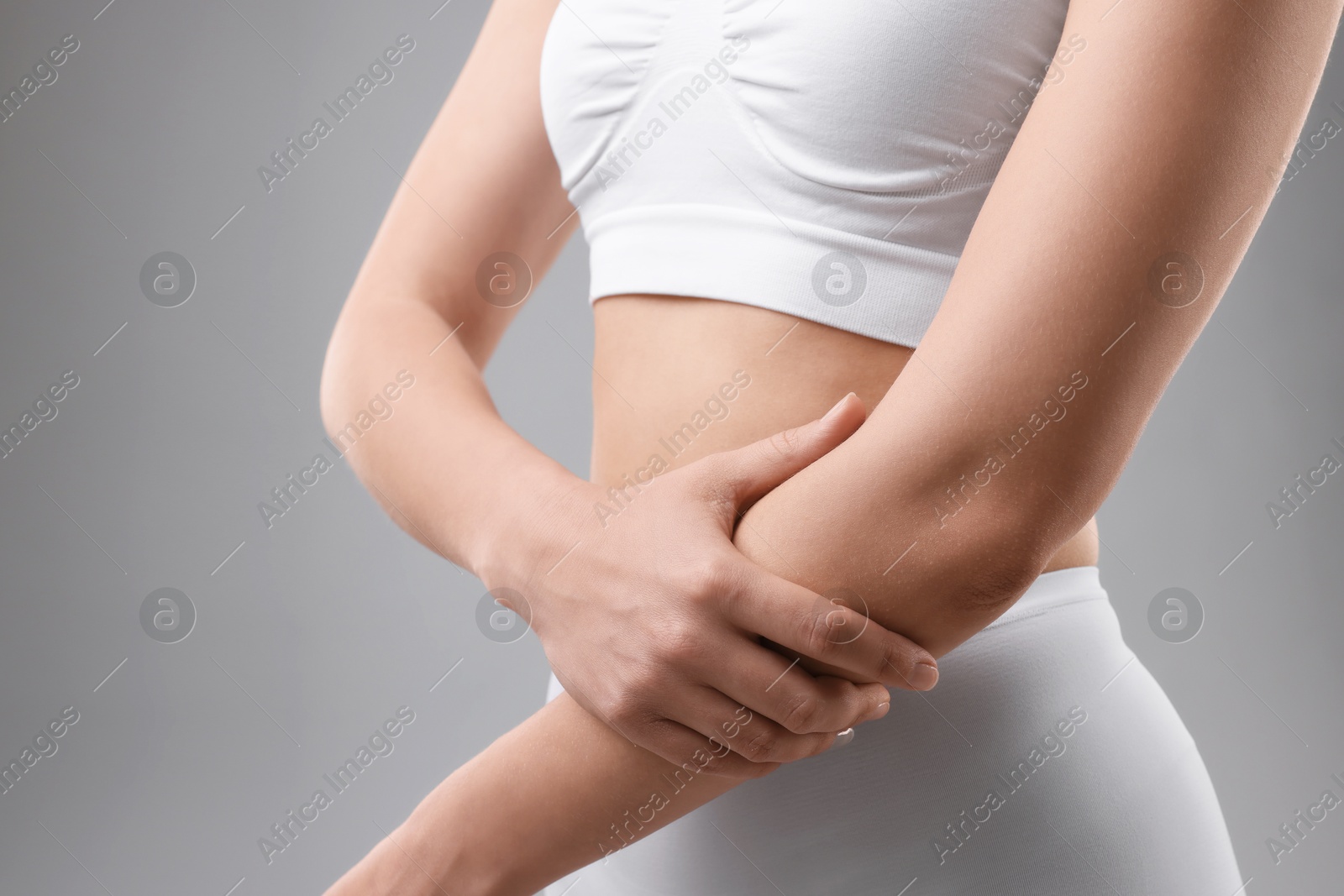 Photo of Sporty woman on grey background, closeup view