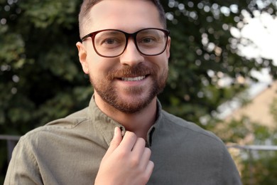 Portrait of handsome bearded man in glasses outdoors