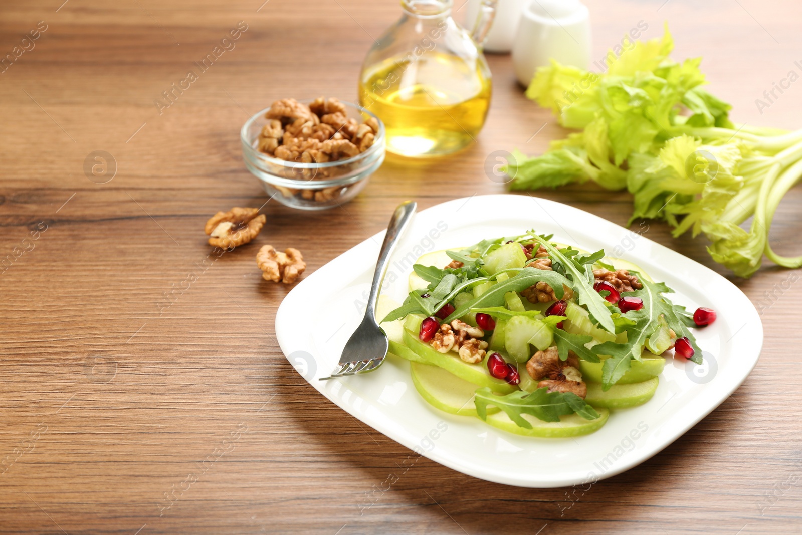 Photo of Delicious fresh celery salad on wooden table. Space for text